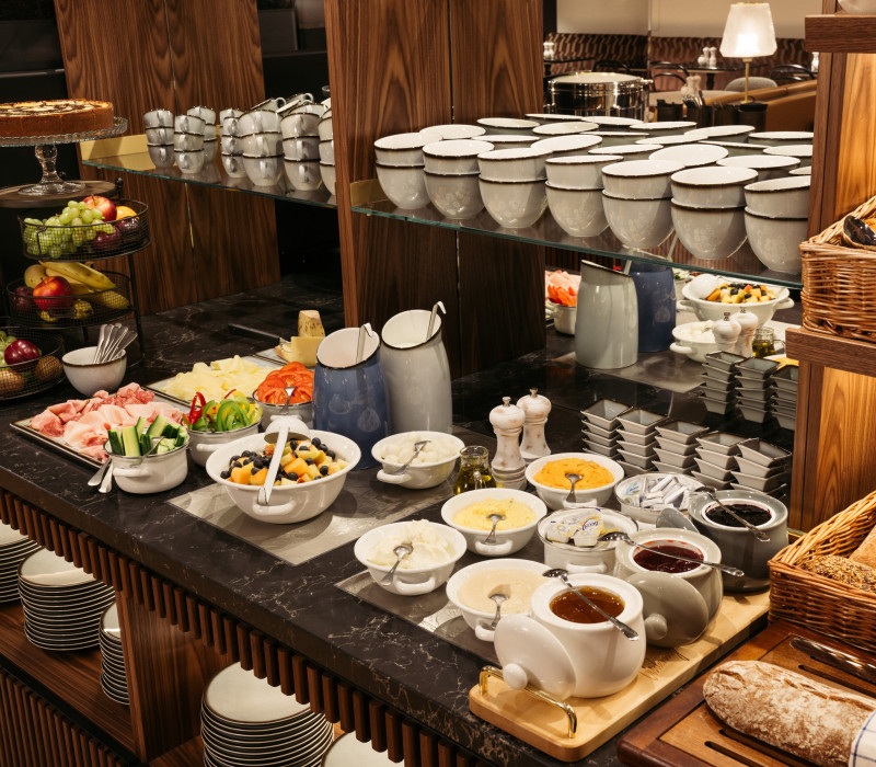 Marmeladen, Aufstriche, Brot, Gemüse und Obstsalat am Frühstücksbuffet im Hotel im Wiener Zentrum 
