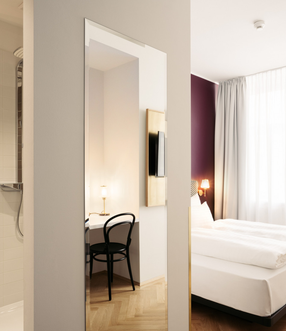 Mirror and bed in a Smart Atrium Room at Hotel Schani Salon