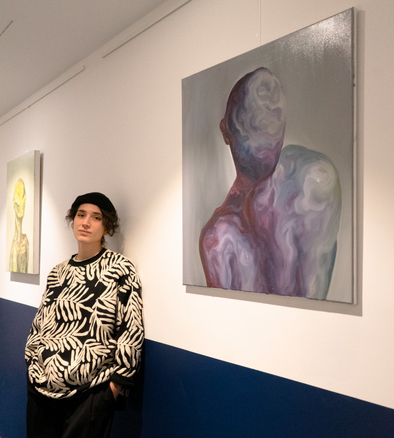 Künstlerin Nina Viola steht vor ihren Kunstwerken